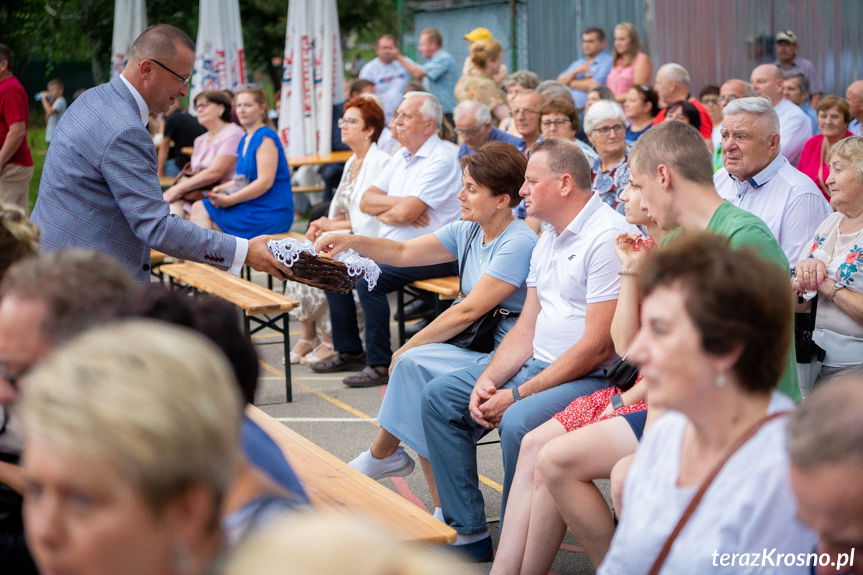 Wójt rozdaje kawalki pochenków chleba podczas dozynek w Świerzowej Polskiej